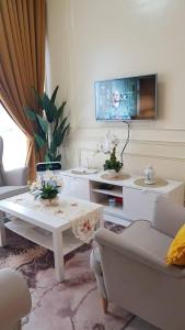 a living room with a table and a tv at Aleeya Suite @ Troika Residence in Kota Bharu