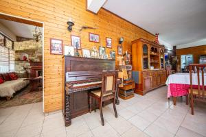a room with a piano and a dining room with a table at Sebastiano Resort in Lezhë