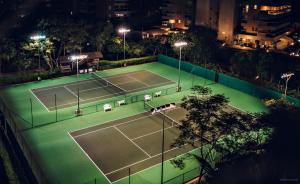 una vista aérea de una pista de tenis por la noche en Pool Ilha da Madeira Resort, en Riviera de São Lourenço 105 fotos más