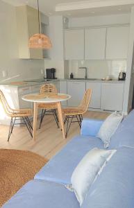 eine Küche mit einem Tisch und Stühlen im Zimmer in der Unterkunft Niechorze Amber Sunset apartment in Niechorze