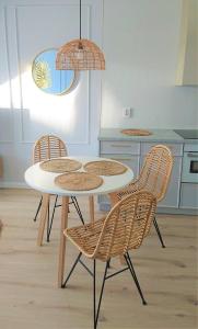 einen Tisch und Stühle in einer Küche mit einer Theke in der Unterkunft Niechorze Amber Sunset apartment in Niechorze