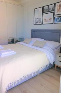 a bedroom with a large bed with white sheets at Niechorze Amber Sunset apartment in Niechorze