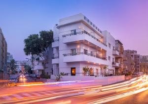 un edificio bianco sul lato di una strada di Brown Golden House, a member of Brown Hotels a Tel Aviv