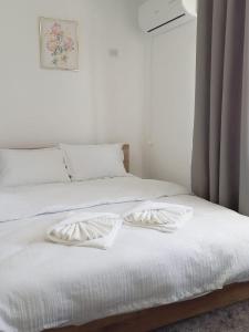 a white bed with two white pillows on it at Casa Alexia in Pescari