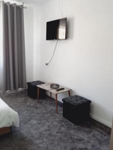 a room with a table and a tv on the wall at Casa Alexia in Pescari +12 photos