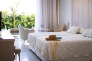a bedroom with a bed with a hat on it at Tasia Maris Beach Hotel - Adults Only in Ayia Napa