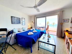 a living room with a blue bed and a large window at Marbellamar Seafront in Cabopino