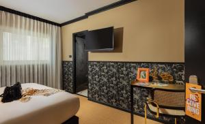 a hotel room with a bed and a desk and a tv at Brown Golden House, a member of Brown Hotels in Tel Aviv