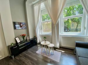 un salon avec une table devant une fenêtre dans l'établissement Art Apartment Szeged, à Szeged