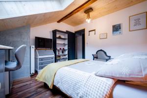 um quarto com uma cama e uma televisão em B&B Restaurant Le Pernollet em Evionnaz