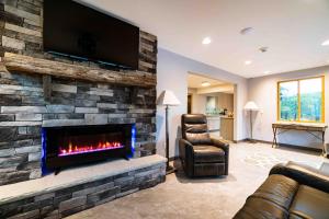 a living room with a fireplace with a tv on a stone wall at The Inn at Canaan in Davis