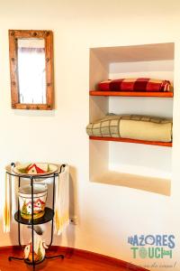 a room with a shelf with a microwave and a mirror at Boina de Vento in Santa Cruz da Graciosa