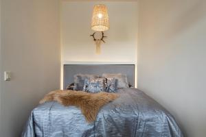 Schlafzimmer mit einem Bett mit blauer Decke in der Unterkunft Tuomas´ luxurious suites, Rakka in Rovaniemi