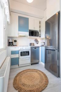 eine Küche mit blauen und weißen Geräten und einem Teppich in der Unterkunft Vasko luxurious suites, Rakka in Rovaniemi + 10 Fotos