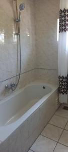 a white bath tub in a bathroom with a shower at 't uiltje in Ermelo