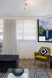 a living room with a yellow chair and a window at Tuynhuys Luxurious with Stunning View in Cape Town