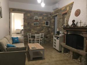 a living room with a couch and a fireplace at ILIOPOULOS Apartments in Mourteri