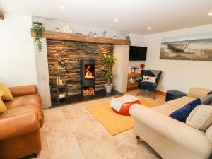 a living room with a fireplace and a couch at Bwthyn Bach Gwyn in Penrhyndeudreath