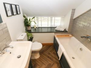 a bathroom with a tub and a toilet and a sink at Bwthyn Bach Gwyn in Penrhyndeudreath +15 photos