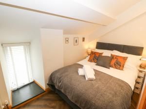 Un dormitorio con una cama grande y una ventana en Bwthyn Bach Gwyn en Penrhyndeudreath