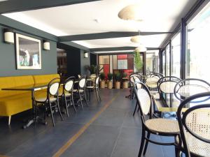 a dining room with tables and chairs and windows at Hôtel Florida in Biarritz