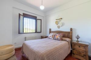 1 dormitorio con cama, mesa y ventana en La Pontezuela Alanis, en Alanís
