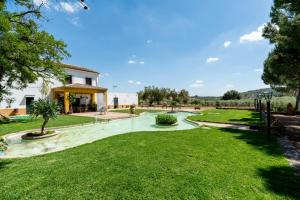 vistas a un jardín con un edificio y árboles en La Pontezuela Alanis, en Alanís