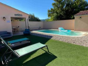 a small swimming pool with a slide in a backyard at Chambre d'hôte au pied du Ventoux in Malaucène
