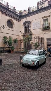 una macchina blu parcheggiata di fronte a un edificio di studionapoli112 a Napoli