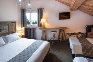 Habitación de hotel con 2 camas y escritorio en Hotel l'Ecureuil, en Auron