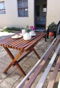 克拉格斯Venolla's的一张木制野餐桌，上面放着两个杯子和盘子。