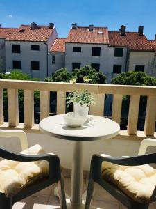 - une table sur un balcon avec un bol et deux chaises dans l'établissement Tatijana Holiday Apartments, à Makarska