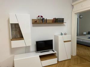 soggiorno con TV su un armadietto bianco di MQ Appartement a Vienna