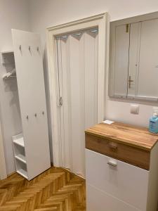 una cucina con armadietti bianchi e pavimenti in legno di MQ Appartement a Vienna