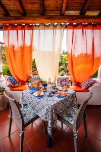 un tavolo con sedie e vasi arancioni sopra di Lauricella Bed and Breakfast a Città di Lipari