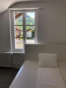 Bett in einem Zimmer mit einem großen Fenster in der Unterkunft Villa Matten in Matten