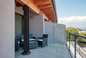 Un balcón con sillas y una mesa en un edificio. en Residenza Puoti, en Peschiera del Garda