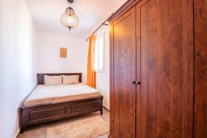 sypialnia z łóżkiem i drewnianą szafą w obiekcie Ilias Cottage w mieście Afiartis