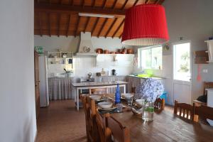 a kitchen with a wooden table and a red lamp at Casa Catita 199 RRAL in Ponta Delgada