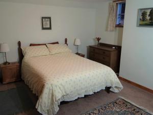 a bedroom with a bed and two night stands at The Cottage Bogroy in Carrbridge