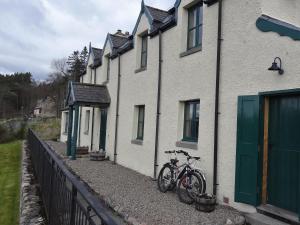 un paio di biciclette parcheggiate fuori da una casa di The Cottage Bogroy a Carrbridge