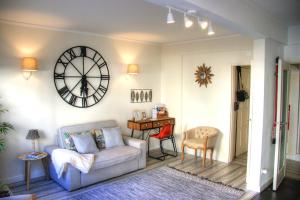 a living room with a couch and a clock on the wall at Beachome4u in Carcavelos