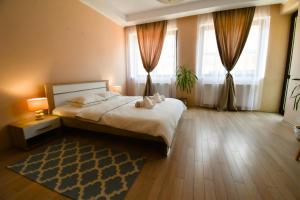 una camera con un grande letto e due finestre di DB Apt - Comfort and Space in the heart of Old Town a Braşov