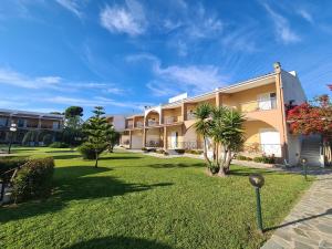 a large apartment building with a green yard at Hotel Kalamitsi Apartments in Preveza