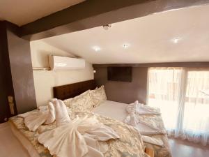 Un dormitorio con una cama grande con sábanas blancas. en Siesta Premium Hotel, en Estambul