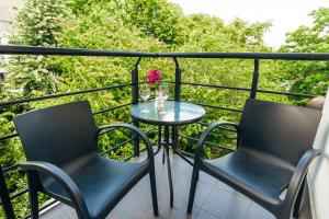 a table and chairs on a balcony with a vase of flowers at TipTop Hotel CITY CENTER in Chişinău