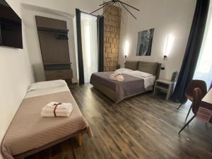 a bedroom with two beds and a table and chairs at Holiday Guesthouse in Salerno