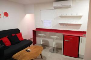 sala de estar con sofá negro y cocina roja en M1 Cool Loft 1 min walk to metro 15 min center by metro, en Esplugues de Llobregat