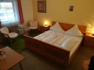 a bedroom with a large bed and a table and chairs at Hotel Waldhaus in Bodenmais