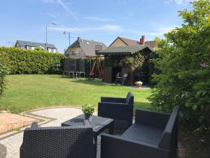 a patio with chairs and a table in a yard at Pokoje Gościnne DANA in Łeba